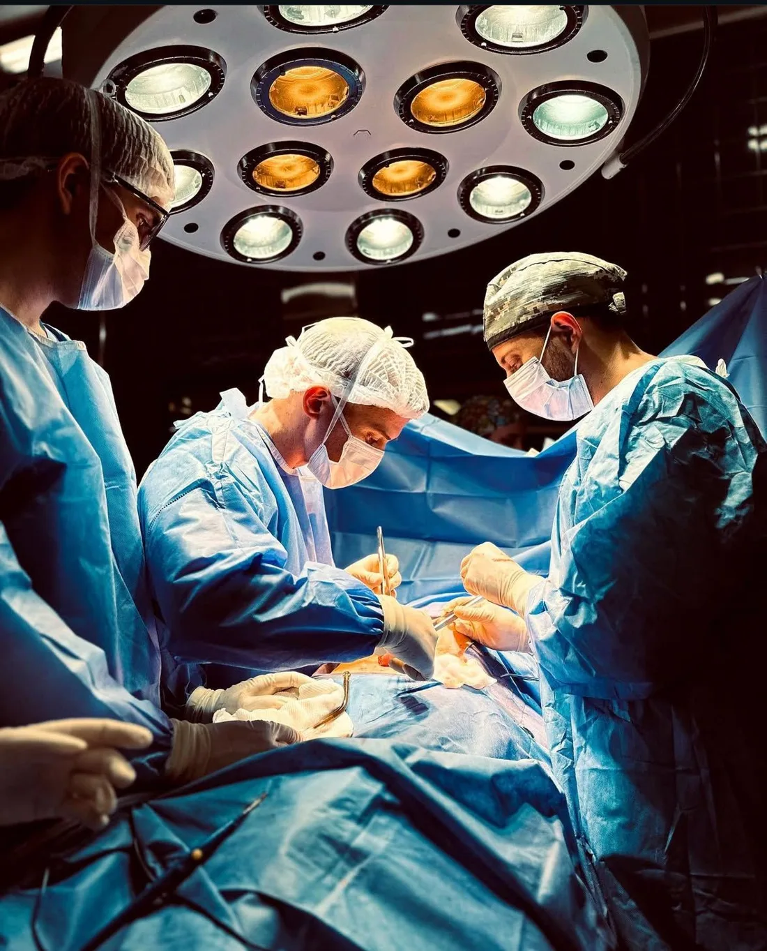 El Dr. Nicolás Lavorato operando junto a su equipo bajo la lámpara del quirófano